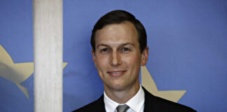 Man in suit with blue and star background.