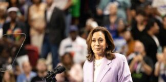 Kamala Harris speaking at podium to crowd.