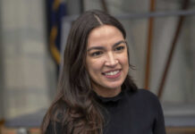 A person smiling, wearing a black shirt.