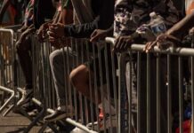 People leaning on barriers at an outdoor event