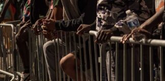 People leaning on barriers at an outdoor event