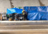 Fraud Scheme Exploits Homeless — Shocking Video! Two people with tarps and shopping carts outdoors