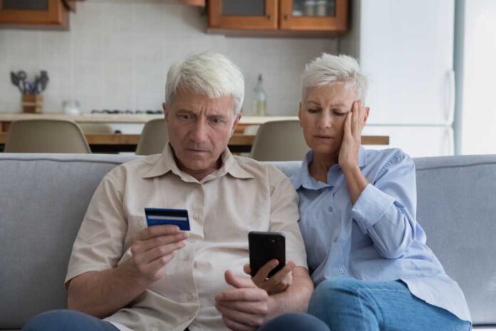aged couple fraud victims_2161635021.jpg old couple with mobile phone and credit card