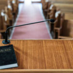 Historic Church Shift: Woman Takes Helm Bible and microphone on a church pulpit