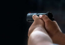 Person holding a black handgun in firing position