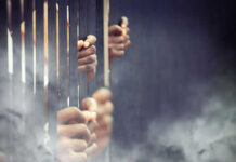 American Hostages in Iran: The Shocking Truth Hands gripping prison bars in smoky atmosphere