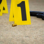 School Shooting Horror – AI’s Role Under Fire Crime scene with evidence markers gun and bullet casings