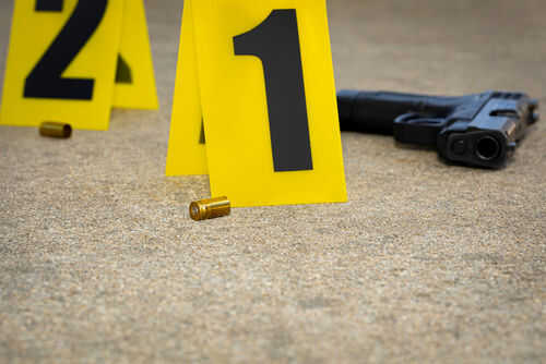 Crime scene with evidence markers gun and bullet casings