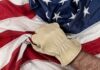 A gloved hand gripping an American flag