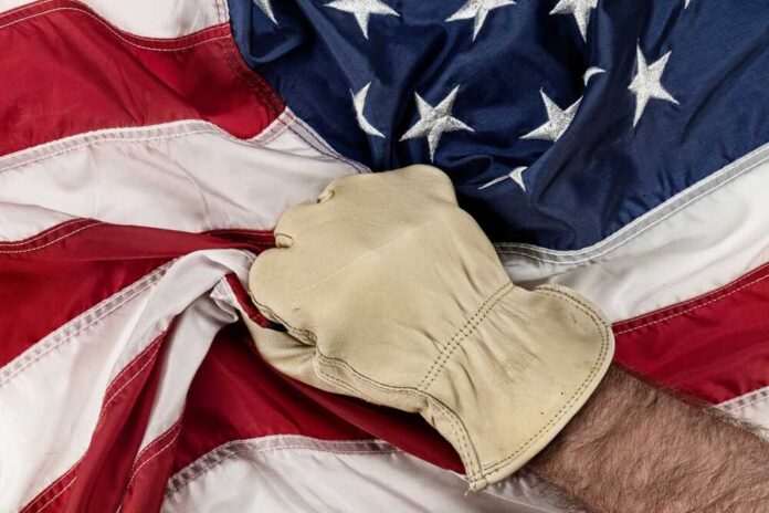 A gloved hand gripping an American flag