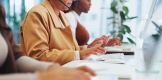 Three women working at a call center, typing on keyboards