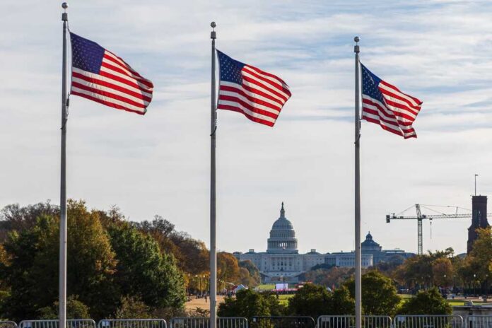 Three American flags waving in front of the Capitol building