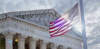 The Supreme Court building with an American flag waving in front