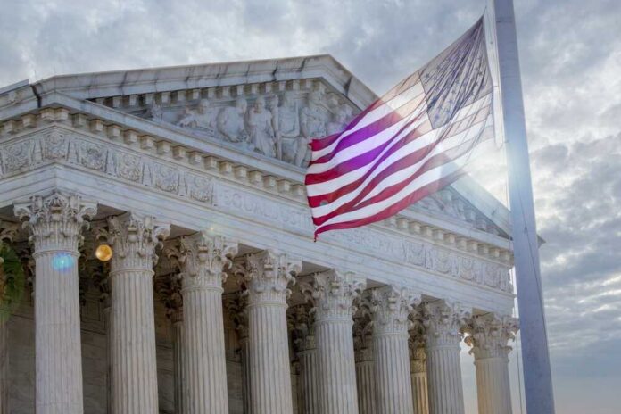 The Supreme Court building with an American flag waving in front