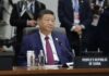Trump’s Summit Delay: Unseen Pressure on China A leader seated at a conference table during an international summit