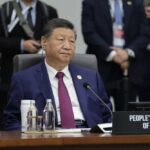 A leader seated at a conference table during an international summit