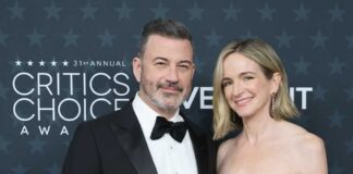 A couple posing together on the red carpet at an awards ceremony