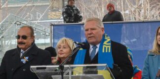 Politician speaking at a rally with supporters in winter attire