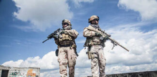 Two soldiers in tactical gear walking in an urban setting