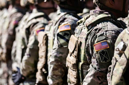 Soldiers in camouflage with American flag patches standing