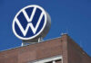 Volkswagen logo atop brick building against blue sky