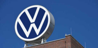 Volkswagen logo atop brick building against blue sky