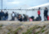 Barbed wire fence in front of blurred people