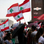 Crowd waving Lebanese flags at outdoor gathering