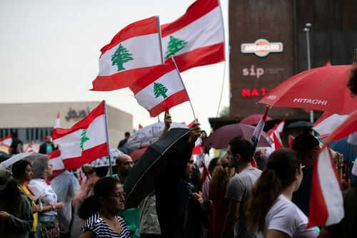 Crowd waving Lebanese flags at outdoor gathering