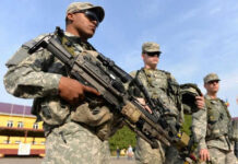 GOP Clash: Iran Ground War Divides Republicans Soldiers in uniform holding weapons outdoors on sunny day