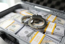 Briefcase with handcuffs and stacks of US dollars