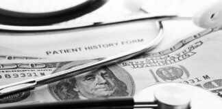 A stethoscope resting on a patient history form and U.S. currency