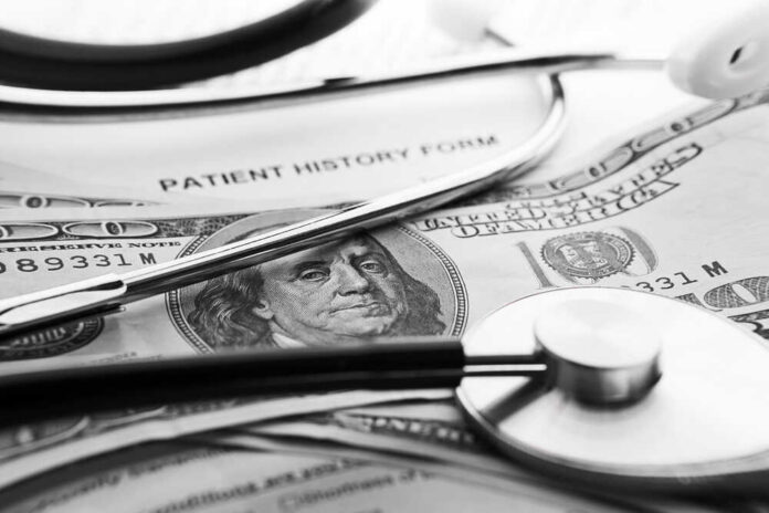 A stethoscope resting on a patient history form and U.S. currency