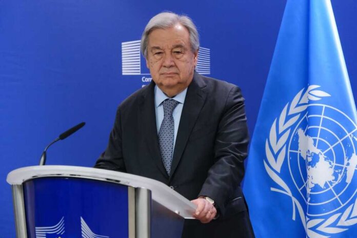 UN Secretary-General at a press conference with the UN flag in the background