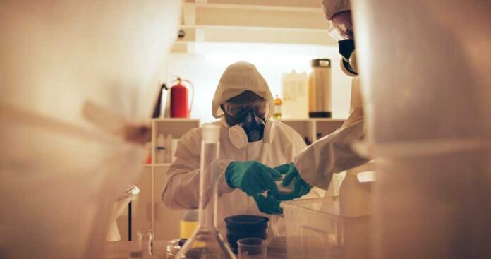 Scientists in protective gear conducting an experiment in a laboratory