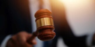 A gavel being struck on a desk in a courtroom setting