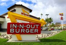 In-N-Out Burger restaurant sign with a bright yellow arrow