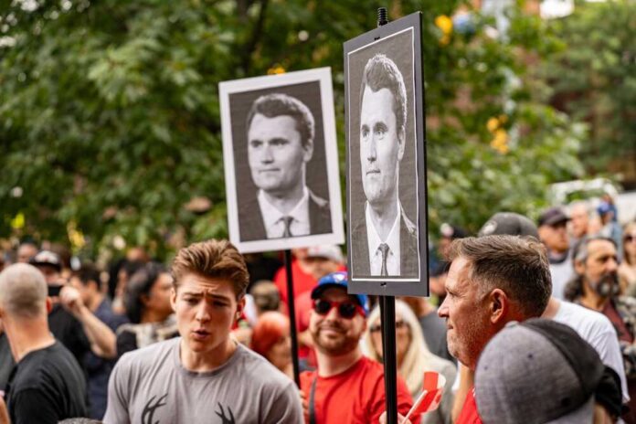 Crowd at a protest holding signs with portraits