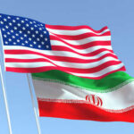 American and Iranian flags waving in the sky.