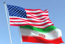 American and Iranian flags waving in the sky.