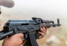 Person holding a rifle outdoors