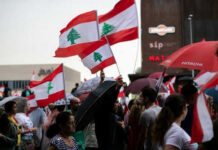 Crowd waving Lebanese flags at outdoor gathering