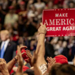 Crowd holding red Make America Great Again sign
