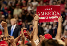 Trump Endorses ‘MAGA Warrior’ Teacher, Igniting Tennessee Race Crowd holding red Make America Great Again sign