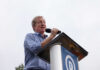 Speaker at a podium addressing an audience outdoors