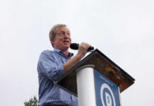 Speaker at a podium addressing an audience outdoors