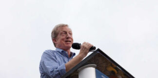 Speaker at a podium addressing an audience outdoors