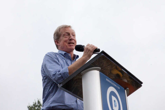 Speaker at a podium addressing an audience outdoors