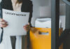 Person holding a layoff notice in an office setting