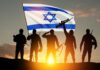 Israeli Commandos SEIZE Gaza-Bound Flotilla! Silhouetted soldiers with rifles stand before an Israeli flag at sunset